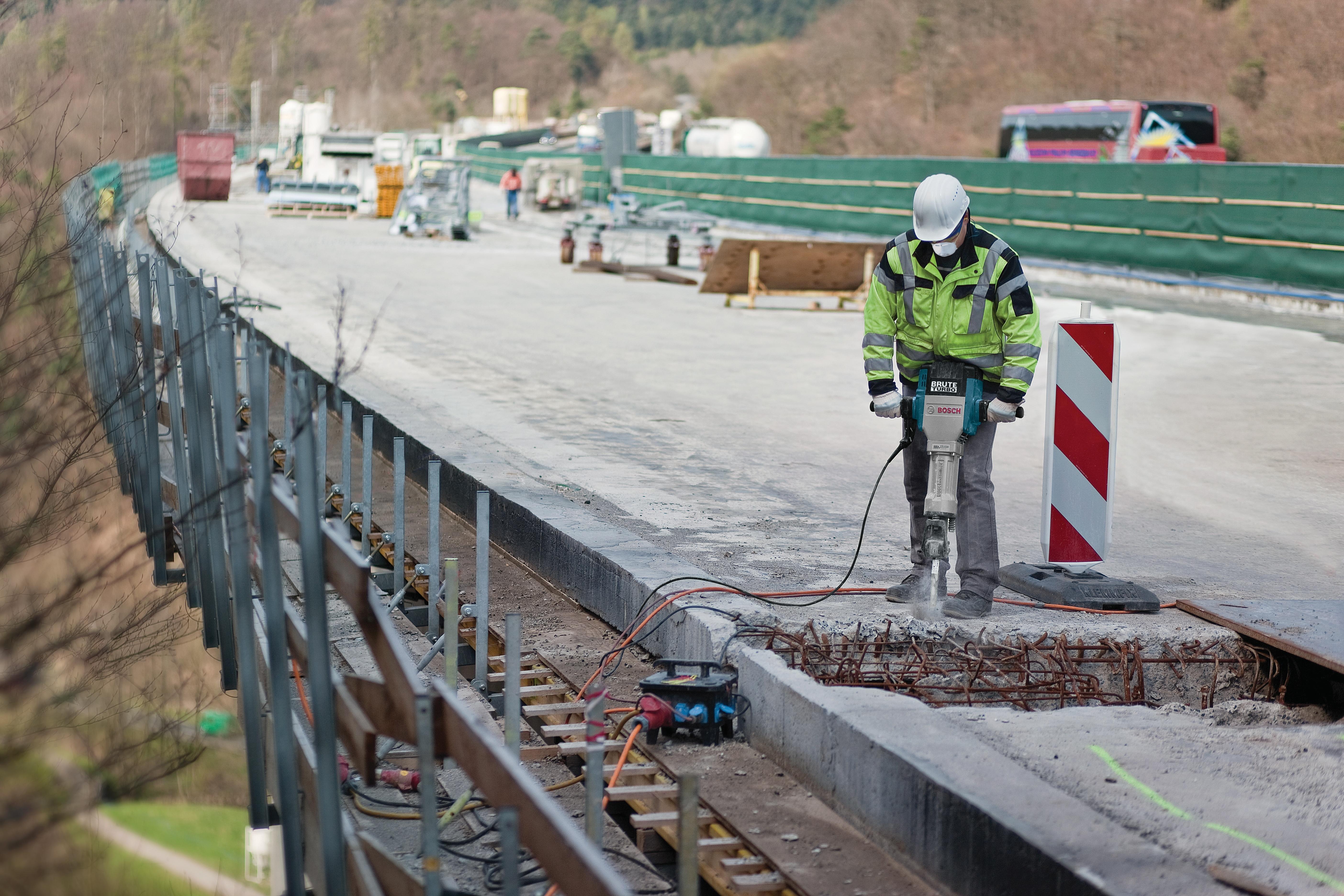 Worker demolishing a bridge parapet with the Bosch Brute Turbo breaker hammer