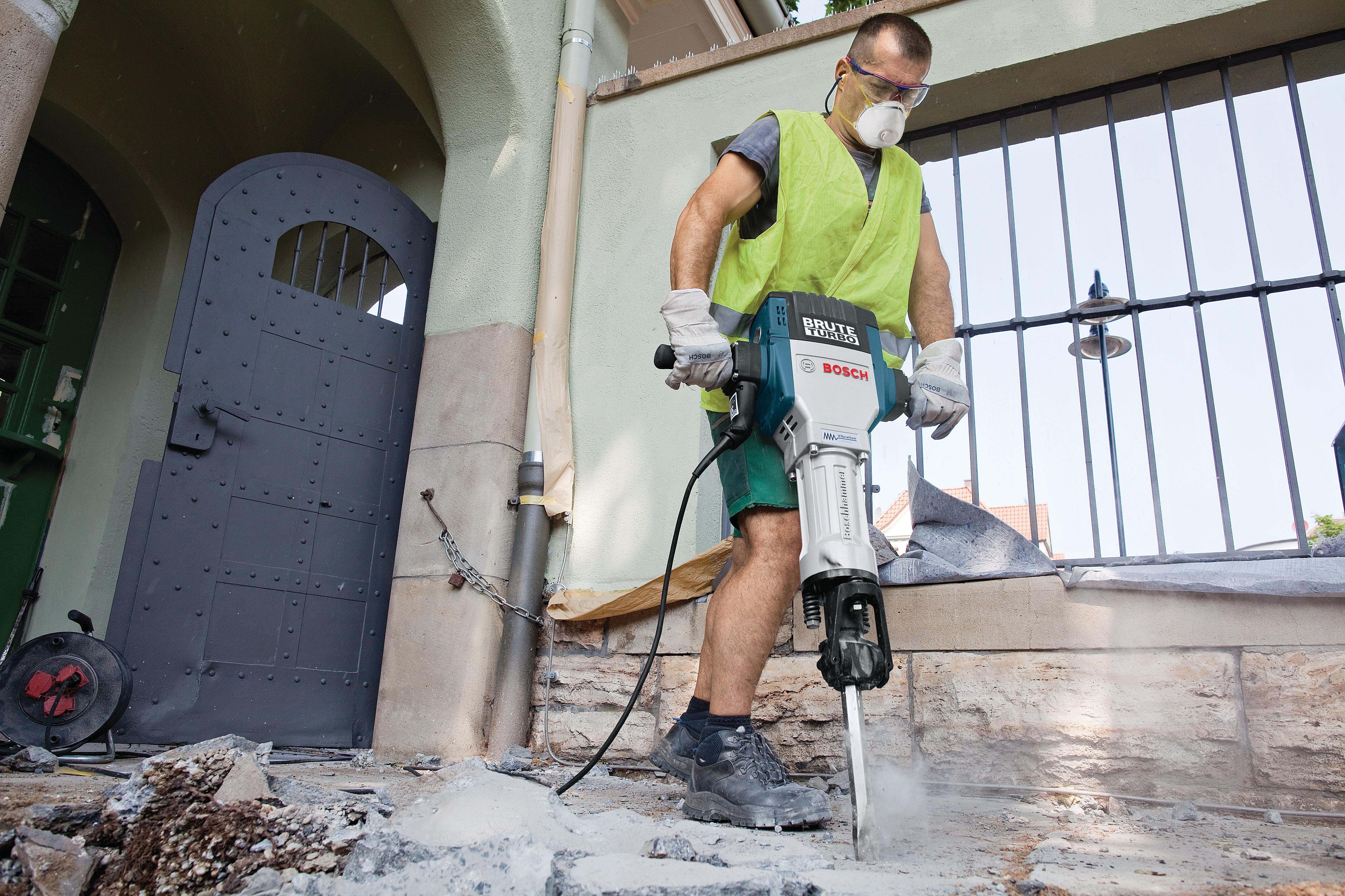 Worker breaking paving at a doorway with the Bosch Brute Turbo breaker hammer