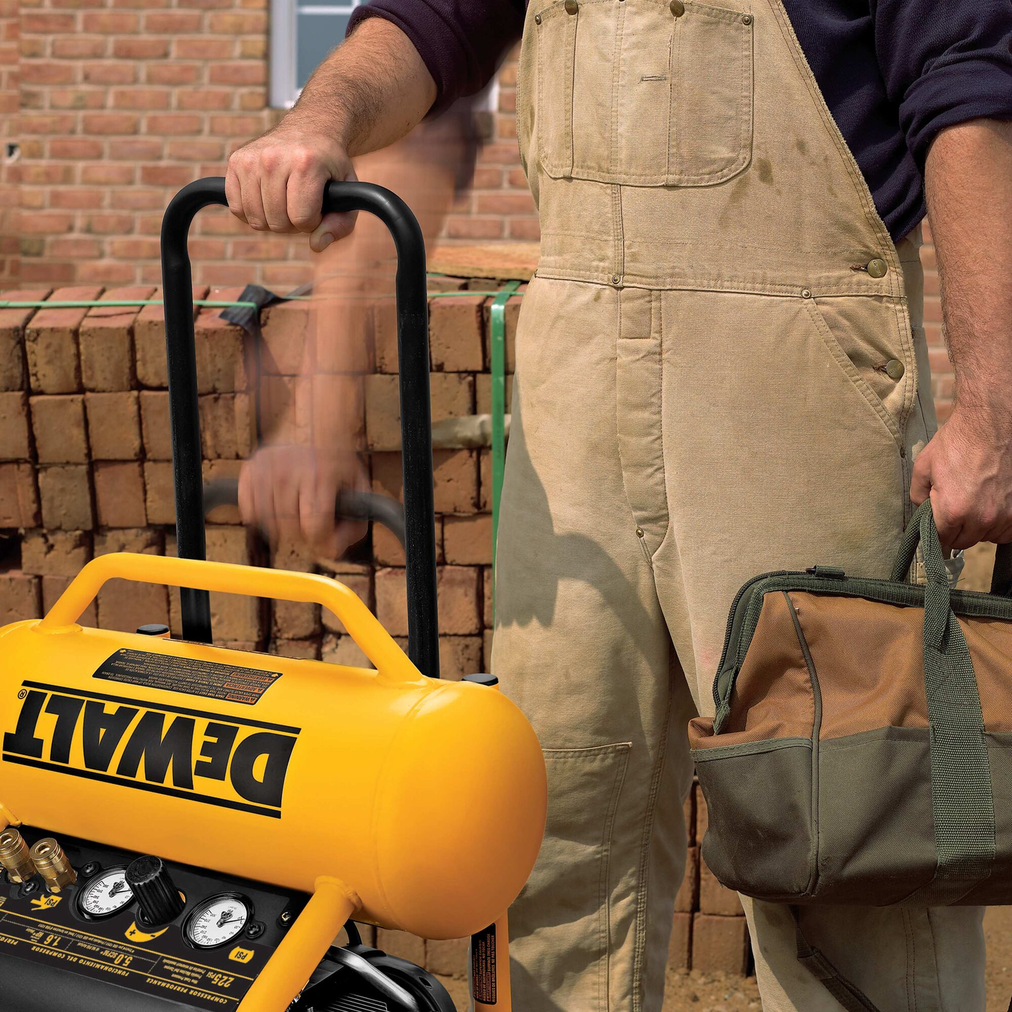 Worker raising the telescoping handle of the DeWalt 4.5 gallon compressor