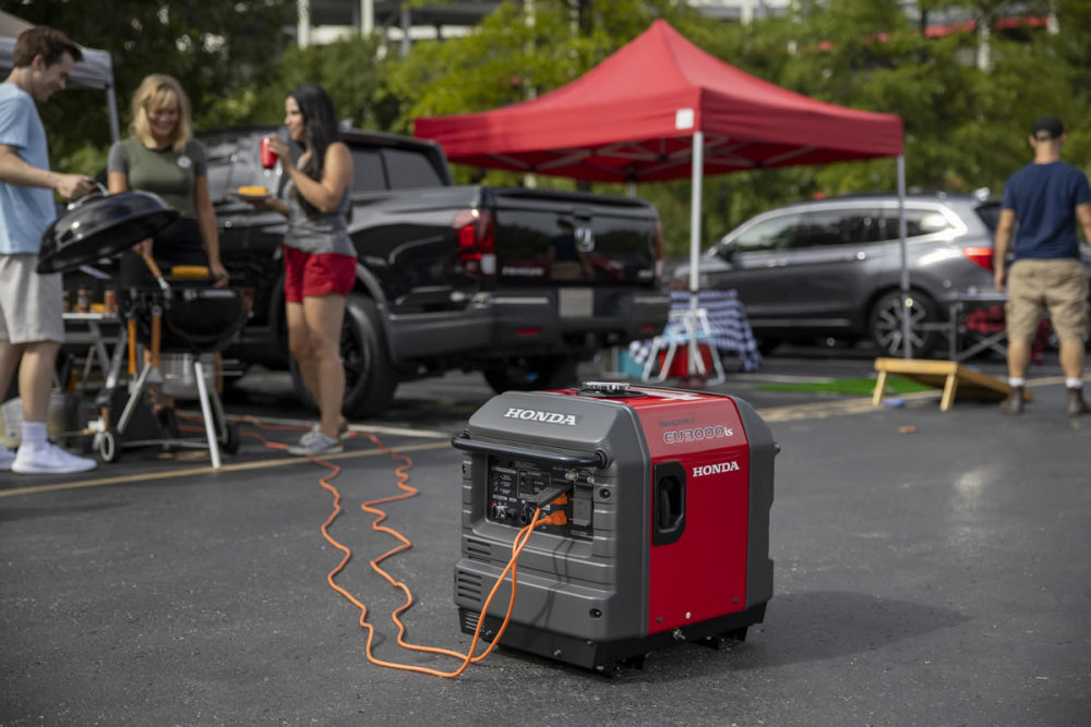 Honda EU3000iS inverter generator powering a tailgate party in a parking lot