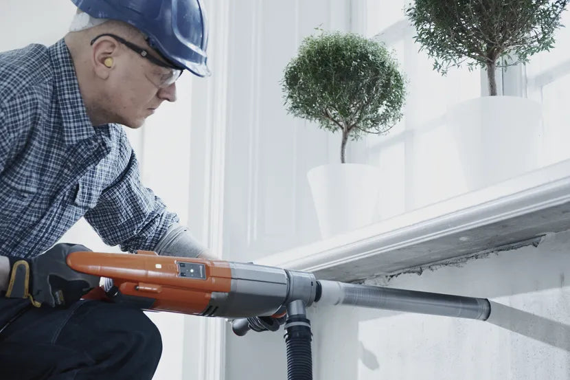 Operator coring through a window reveal with the Husqvarna DM 220 handheld drill