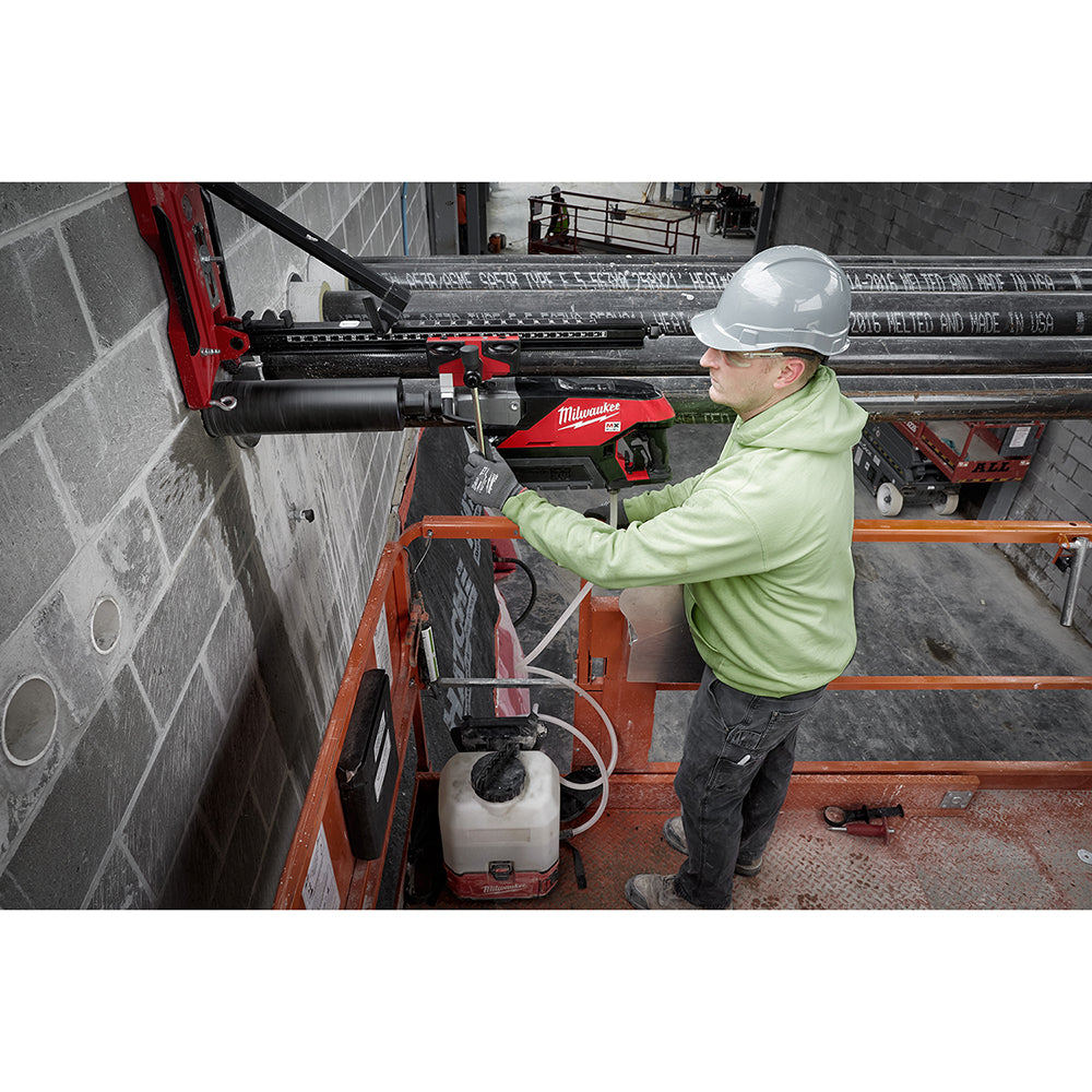 Operator coring a block wall from a lift with the MX FUEL drill on its compact stand