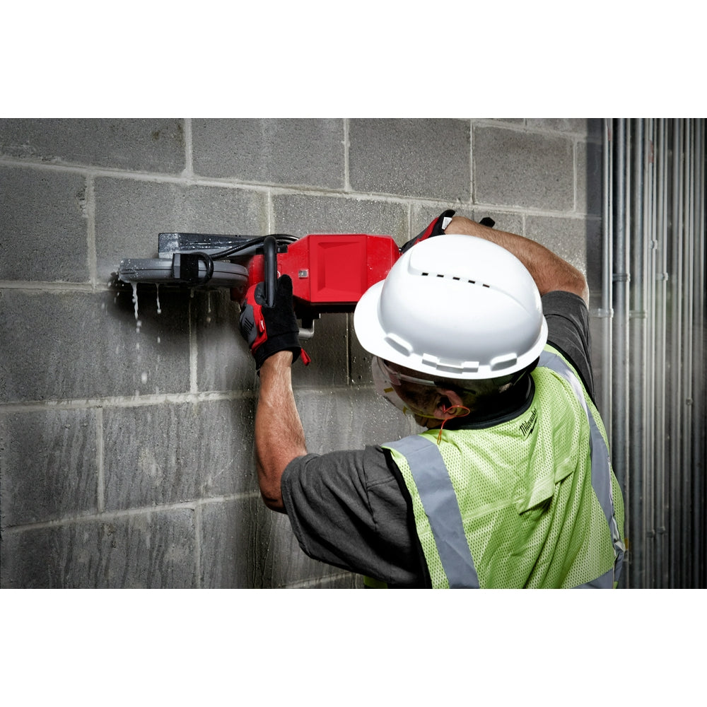 Worker cutting a block wall with the M18 FUEL cut-off saw and water feed