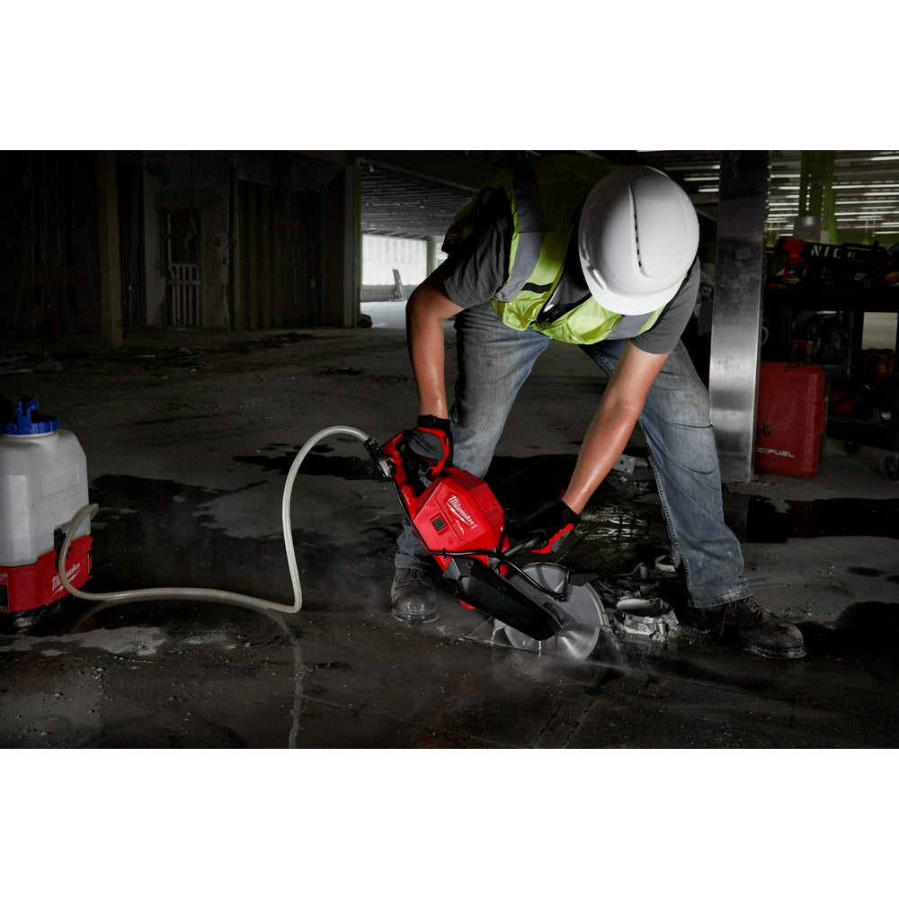 Worker cutting a concrete slab with the M18 FUEL cut-off saw and a water supply