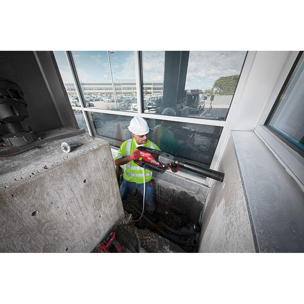 Operator coring a floor beside a window with the MX FUEL handheld core drill